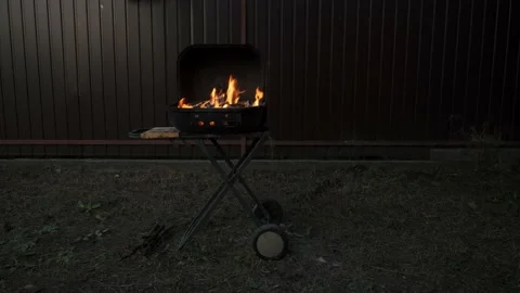 The grill is outside in the backyard. A barbecue fire is burning. Stock Footage 223371179