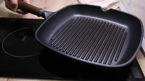 Grill pan placed on the stove Stock Footage 247500381