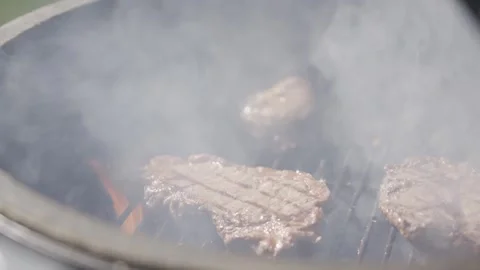 A grill with three pieces of meat on it, one of which is a steak Stock Footage 301630021