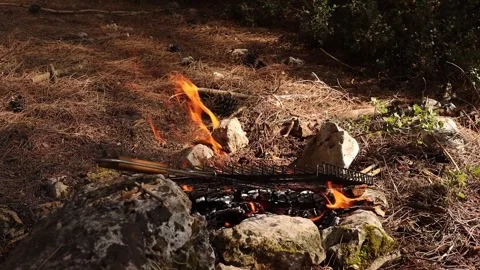 Grill Wire on the Campfire with Dry Grasses in the Background (Slow Motion) Stock Footage 325654102