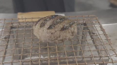 Grilled A5 Wagyu Beef Patty Sizzling on Wire Mesh Rack 4K Stock Footage 341420960