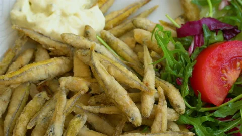 Grilled and fried small fish on a traditional Mediterranean plate garnished with Stock Footage 106628808