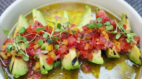 Grilled avocado slices topped with fresh vegetable salsa and herbs in a lig.. Stock Footage 339511348