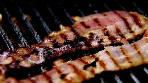 Grilled bacon strips capture essence of sizzling goodness, ready to be devoured. 스톡 동영상 334643425