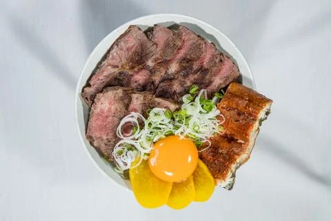 Grilled beef and eel rice bowl with egg yolk Stock Photos