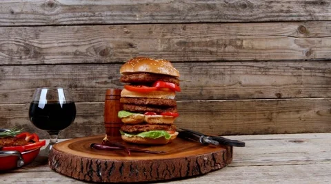 Grilled beef huge hamburger served on wood plate with red wine Stock Footage 63918937