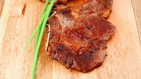 Grilled beef ribs served with green chives on wooden table Stock Footage 78772855