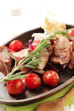 Grilled beef steak with cherry tomatoes and herbs Stock Photos