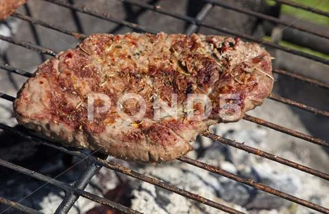 Grilled beef steak cooking on barbecue grill Stock Photos