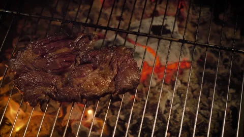 Grilled beef steak (medium well). Weak coals, camera movement. 4K, dark scene. Stock-Footage 135608454