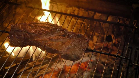 Grilled beef steak (medium well). Strong fire, flames, camera movement. 4K. Stock Footage 135612938