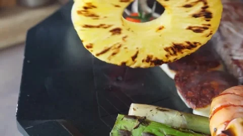 Grilled Beef Steak with Pineapple Rings and Vegetables on Barbecue Grill Stock Footage 338210886