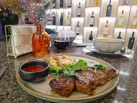 Grilled beef steak on the table in a fancy restaurant with a view to the wi.. Stock Photos