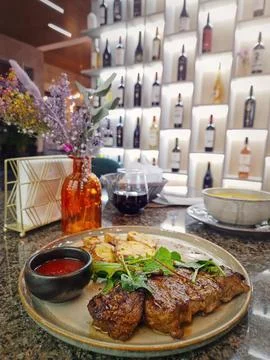 Grilled beef steak on the table in a fancy restaurant with a view to the wi.. Stock Photos