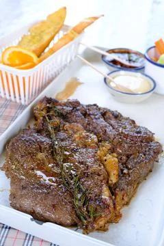 Grilled beef steaks with cream source on white plate Stock Photos