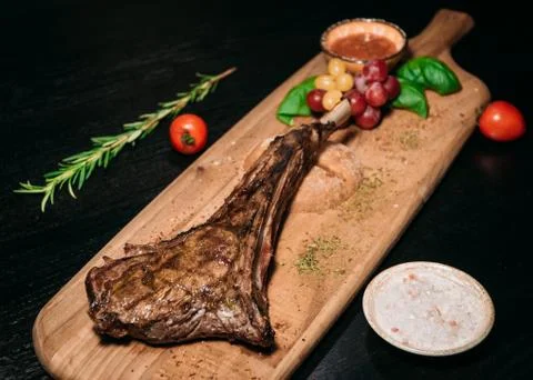 Grilled beef tomahawk steak on a board Stock Photos