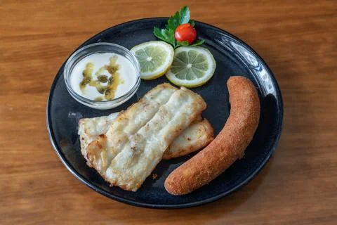 Grilled black cod fillets served with passion fruit sauce, lemon slices, and a Stock Photos
