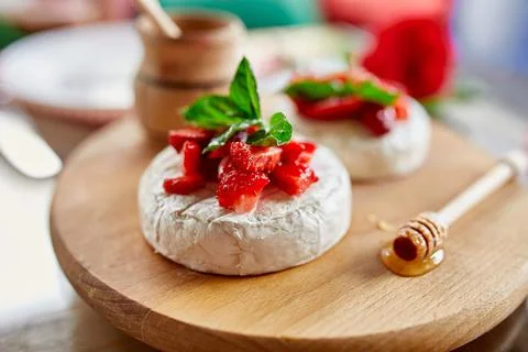 Grilled camembert cheese with strawberry, honey and basil leaves, delicatesse Stock Photos