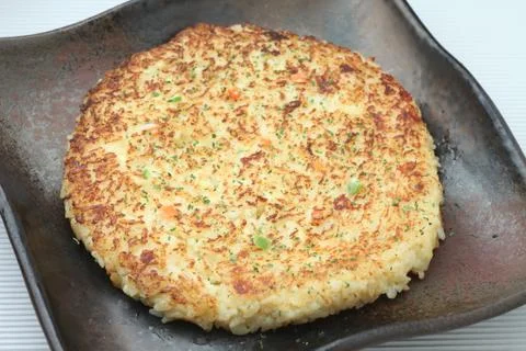Grilled cheese risotto or rice pancake in Japanese style on black dish Stock Photos