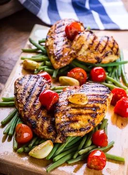 Grilled chicken breast in different variations with cherry tomatoes, green .. Stock Photos