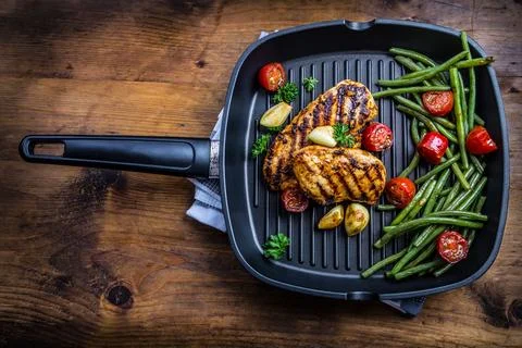 Grilled chicken breast in different variations with cherry tomatoes, green .. Stock Photos