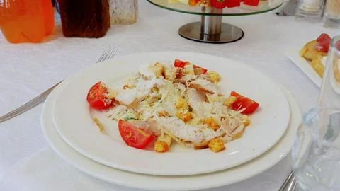 Grilled chicken caesar salad presenting crisp lettuce, juicy cherry tomatoes Stock Photos