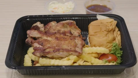 Grilled Chicken Chop with Crinkle Cut Fries, Bun and Side Salad in Takeaway Tray Vídeo Stock 346504186
