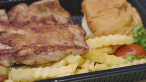 Grilled Chicken Chop with Crinkle Cut Fries, Bun and Side Salad in Takeaway Tray Vídeo Stock 346504187