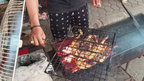 Grilled chicken is cooked on fire and coals on one of the streets of Indonesia. Stockbeeldmateriaal 238917271