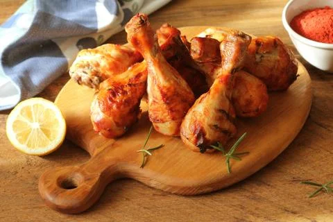 Grilled chicken legs on cutting board. Rustic dinner background Stock Photos