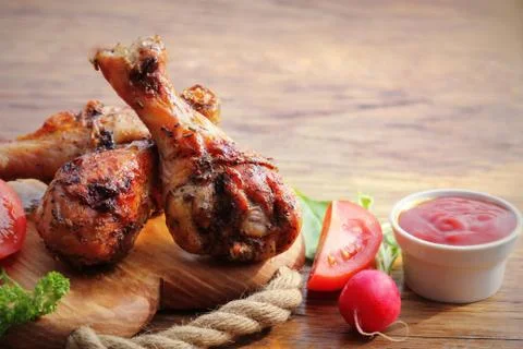 Grilled chicken legs on cutting board.Rustic dinner background Stock Photos