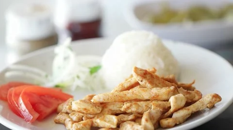 Grilled chicken rotating slow motion on plate with rice, onion and tomatoes. Stock-Footage 62262771