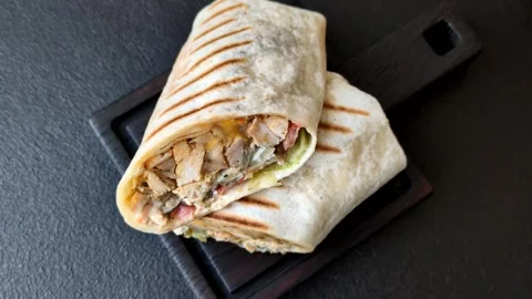 Grilled chicken shawarma or doner with tomatoes, cucumber, and sauces, takeout f Stock Footage 340288048