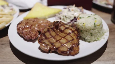 Grilled chicken steak served on a white plate with fried rice, garlic bread.. Stock Footage 343114545