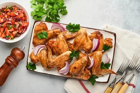 Grilled chicken wings or roasted bbq with spices and tomato salsa sauce on pl Stock Photos