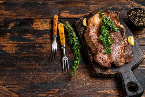Grilled Chuck eye roll beef meat steak on a cutting board. Dark wooden Stock Photos