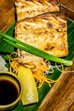 Grilled cod fish with a wedge of lemon and soy sauce on the side Stock Photos