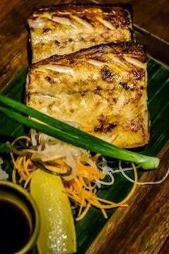 Grilled cod fish with a wedge of lemon and soy sauce on the side Stock Photos
