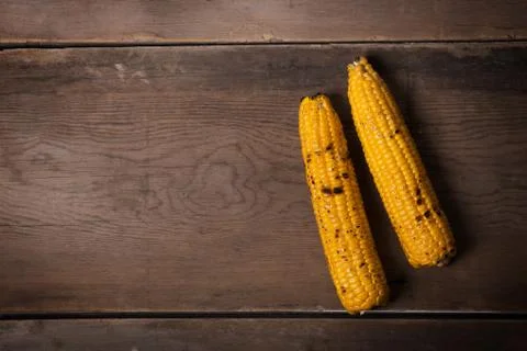 Grilled corn cobs on the brown rustic background. Top view with copy space 写真素材