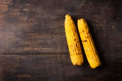 Grilled corn cobs on the brown rustic background. Top view 写真素材
