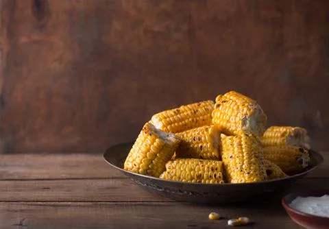 Grilled corn cobs on the brown rustic background. Horizontal orientation with Foto stock