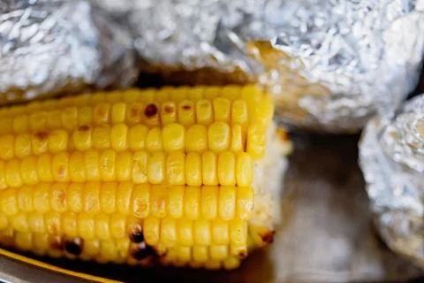 Grilled corn cobs on tin foil Stock Photos
