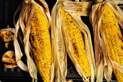 Grilled corn process, roasted young corn close-up, top view Foto stock