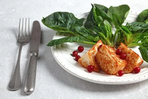 Grilled curd cheese mozzarella halloumi with green spinach and lingonberry Stock Photos