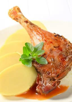 Grilled duck leg with mashed potatoes and mint garnish Stock Photos