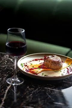 Grilled fillet steaks on a ceramic plate and glass of red wine Stock Photos
