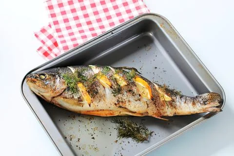 Grilled fish on a baking tray with herbs Stock Photos