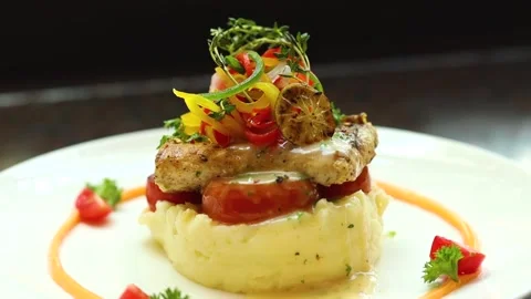 Grilled fish with mashed potato and veggies on top served on a white plate Stock Footage 302906204