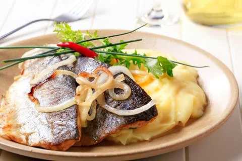 Grilled fish with mashed potatoes and garnish Stock Photos