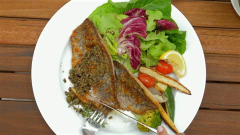 Grilled fish with mixed greens, cherry tomatoes, baby corn, and lemon Stock Footage 284209195